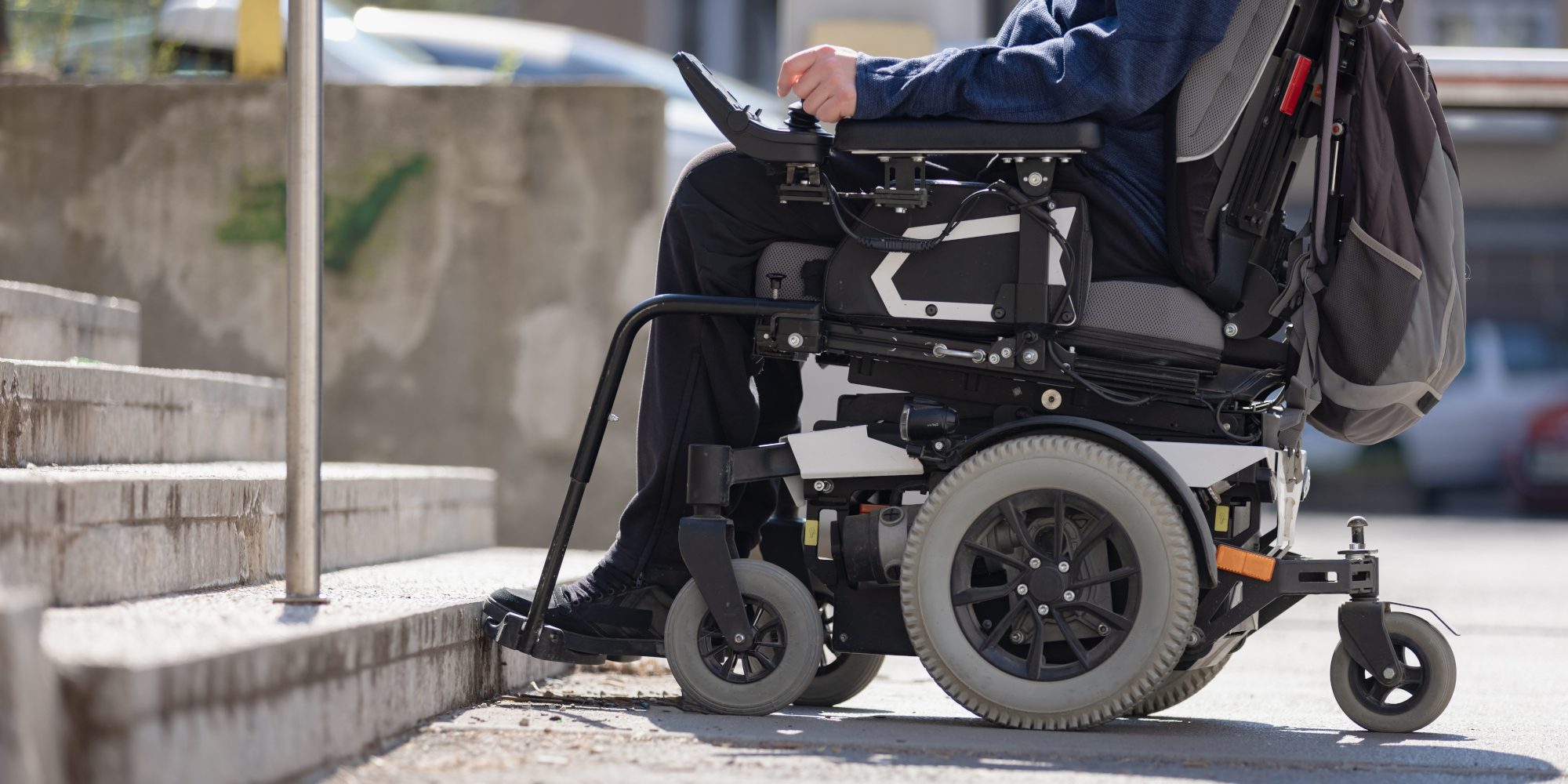 Man,With,Disability,On,Wheelchair,Stopped,In,Front,Of,Staircase,